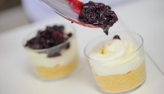 Dessert al bicchiere con crema e frutti di bosco.