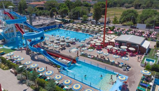 Parco acquatico con scivoli, piscine e ombrelloni colorati.