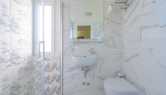 Bagno moderno con piastrelle marmo e doccia.