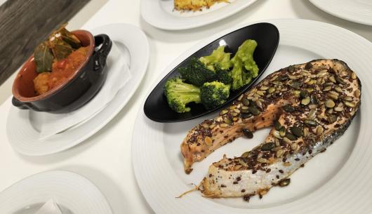 Salmone con semi, broccoli e stufato in pentola.